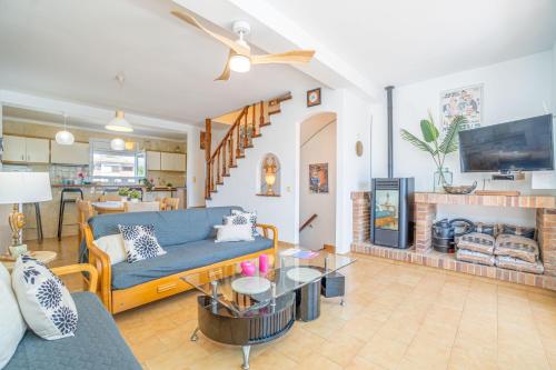 sala de estar con sofá azul y chimenea en Basic Comfort Casa al canal Porto Fino 0153, en Empuriabrava