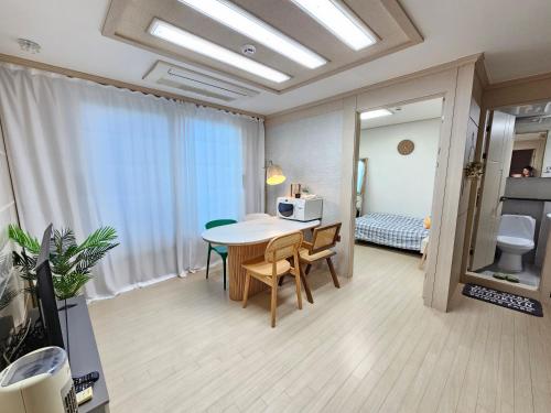 Zimmer mit einem Tisch und Stühlen sowie einem Schlafzimmer in der Unterkunft My comfortable second house in Seoul