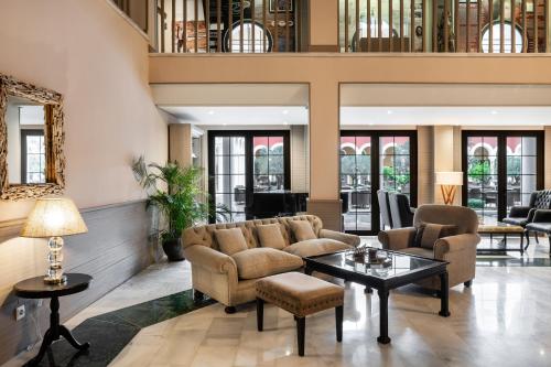 a living room with couches and a table at Palacio de Sancti Petri, a Gran Meliá - The Leading Hotels of the World in Chiclana de la Frontera