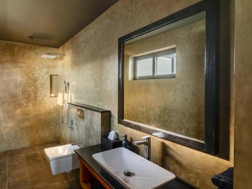 a bathroom with a sink and a mirror at DORMERO Hotel Sri Lanka Hikkaduwa Beach in Hikkaduwa