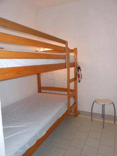 - une chambre avec 2 lits superposés et une chaise dans l'établissement APPT 3 PIECES 32m2 + TERRASSE 13m2 REF 4050, à Le Castellas