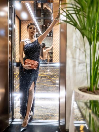 a woman in a dress standing in front of a mirror at Golden Sands Boutique Hotel-Dubai Creek in Dubai