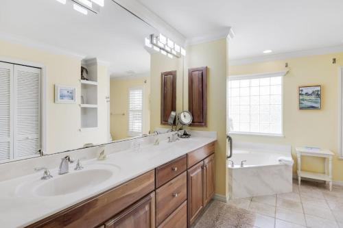 a bathroom with two sinks and a large mirror at Gorgeous 5 Bedroom Home with Heated Pool and Spa in Sanibel