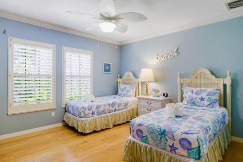 a bedroom with two beds and a ceiling fan at Gorgeous 5 Bedroom Home with Heated Pool and Spa in Sanibel