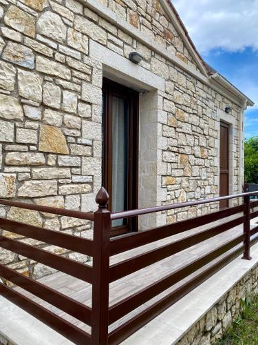 a stone house with a wooden fence on a porch at Villa Maria 1 in Gliki