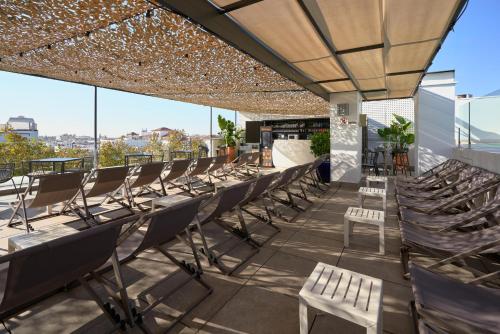 uma fila de cadeiras e mesas no telhado de um edifício em Hotel Bécquer em Sevilha