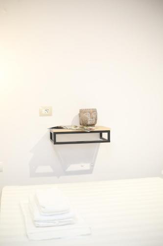 a shelf in a white room with a plate on it at TekB Rooms & Apartments in Vlorë