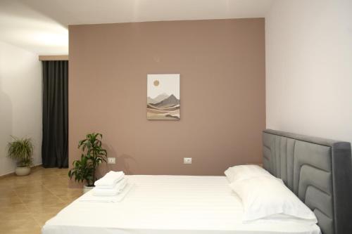 a bedroom with a bed with white sheets at TekB Rooms & Apartments in Vlorë