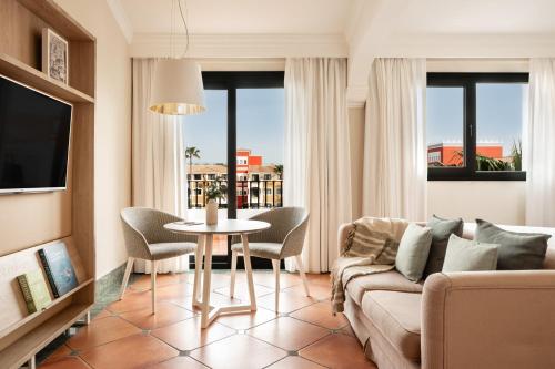 a living room with a couch and a table at Palacio de Sancti Petri, a Gran Meliá - The Leading Hotels of the World in Chiclana de la Frontera