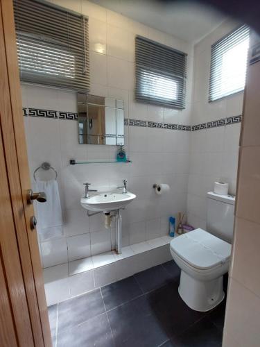 a white bathroom with a toilet and a sink at All Seasons Guest House in Windermere