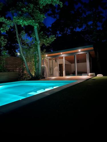 dom z basenem w nocy w obiekcie Pine-Wood Resort w mieście Balatonalmádi