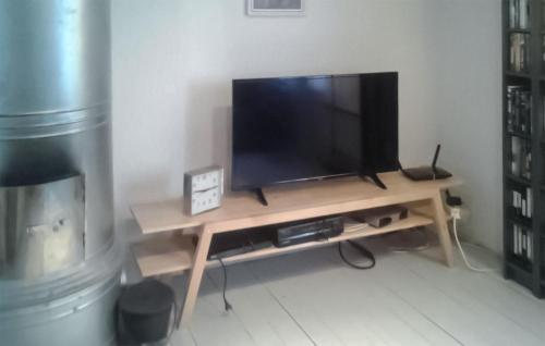 a television on a wooden stand in a living room at Lovely Home In Överkalix With Sauna in Överkalix