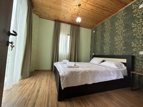 sypialnia z łóżkiem i drewnianym sufitem w obiekcie WoodStar w mieście Ambrolauri