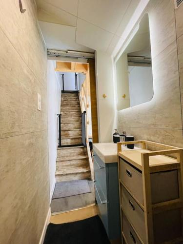 La salle de bains est pourvue d'un escalier avec un lavabo et un escalier. dans l'établissement L'Alma 8 : Le Calme au Coeur de Cherbourg, à Cherbourg en Cotentin