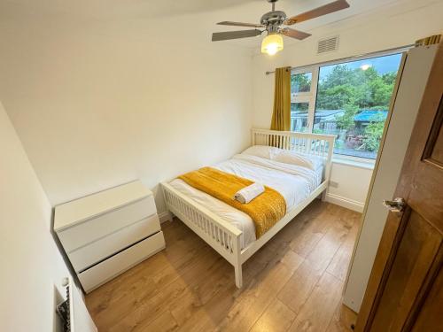 a small bedroom with a bed and a window at Golden Villa in Uxbridge