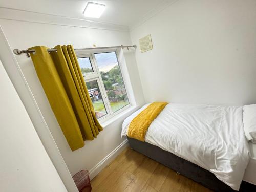 a bedroom with a bed and a window at Golden Villa in Uxbridge