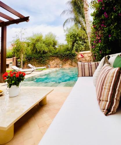 een patio met een bank en een zwembad bij Villa Jenna in Marrakesh