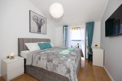 1 dormitorio con 1 cama grande y TV en Apartments Ana en Trogir