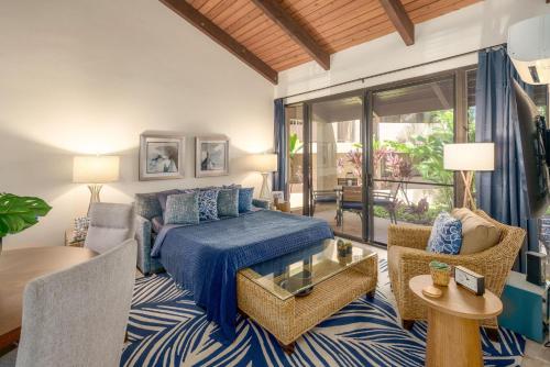 a bedroom with a bed and a living room at Kamaole Sands 7-100 in Wailea