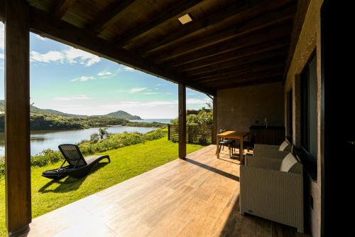 une maison avec une terrasse offrant une vue sur la rivière dans l'établissement Fazenda Verde - Praia do Rosa, à Praia do Rosa