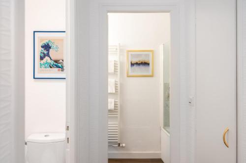 サン・マロにあるHotel Elizabeth - Intra Murosの白いバスルーム(トイレ付)が備わります。壁には絵画が飾られています。