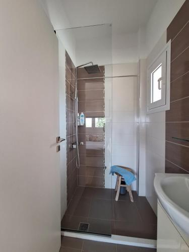 a bathroom with a shower with a blue stool in it at Villa Irini - Cretan Luxury Villa with Amazing View in Paraspórion