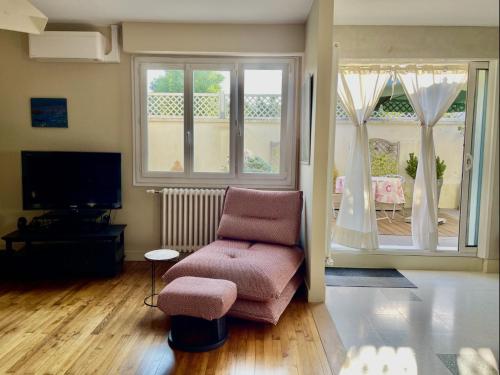 un salon avec une chaise et une fenêtre dans l'établissement Family house, à La Rochelle
