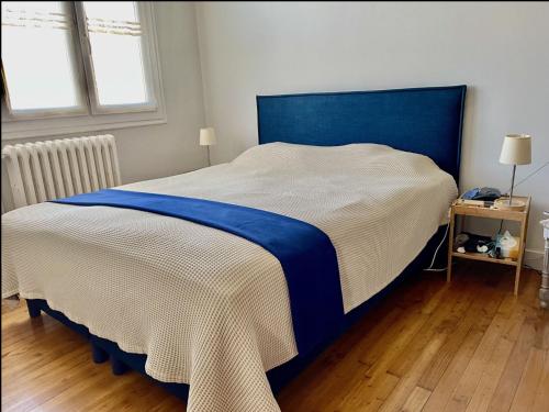 un grand lit avec une tête de lit bleue dans une chambre dans l'établissement Family house, à La Rochelle