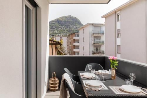 a table on a balcony with a view of a mountain at Lugano Superior Suites - Free Parking in Lugano