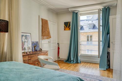 une chambre avec un lit et une grande fenêtre dans l'établissement Appartement Saint Louis Luxury, à Paris