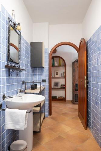 a bathroom with a sink and blue tiles at Ca Cele Viola by Klodge in Olbia