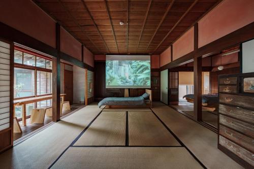 una sala de estar con una pantalla grande en el centro en La casa di Endo - Vacation STAY 17606v, en Nishinoomote