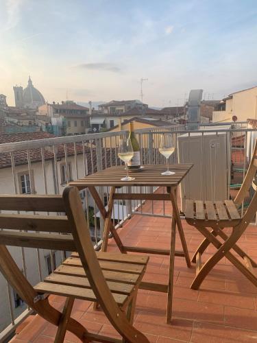 a table and two chairs on a balcony with wine glasses at Kairos by Florence Art Apartments in Florence