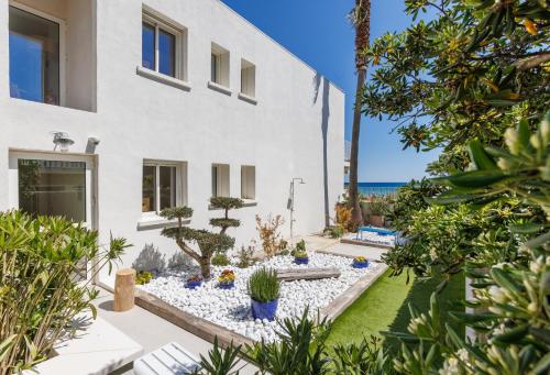 a garden with cacti and plants in front of a building at Belle Vue H&ocirc;tel in Cavalaire-sur-Mer