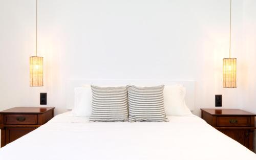 a bedroom with a white bed with two night stands at Laza Beach in Skala