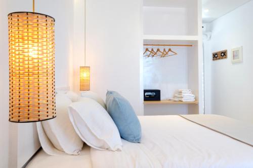 1 dormitorio con cama blanca y lámpara de araña en Laza Beach en Skala