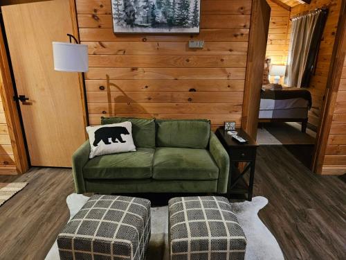 sala de estar con sofá verde y 2 reposapiés en Sylvan Valley Lodge and Cellars en Sautee Nacoochee