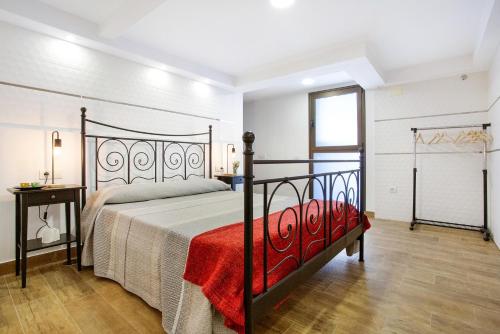 a bedroom with a bed with a red blanket at Las Palmeras in Güimar
