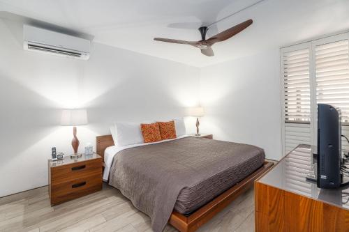 a bedroom with a bed and a flat screen tv at Kamaole Sands 3-303 in Wailea