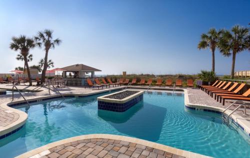 duży basen z krzesłami i palmami w obiekcie Best Western Ocean Sands Beach Resort w mieście Myrtle Beach