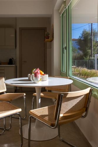 a table and chairs in a room with a window at Kallisti Stay in Artemida
