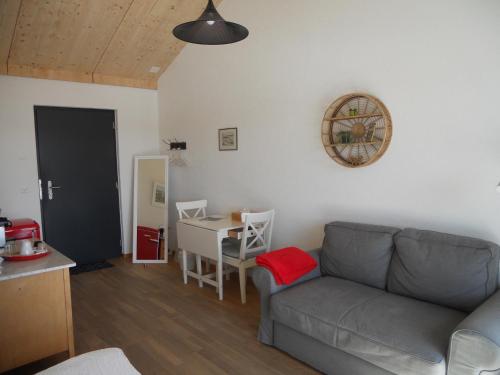 ein Wohnzimmer mit einem Sofa und einem Tisch in der Unterkunft Gîte Chez Toinette in Saignelégier