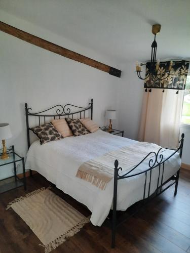 - une chambre dotée d'un grand lit avec des draps et des oreillers blancs dans l'établissement gîte grange le Kulmino, à Notre-Dame-de-Monts