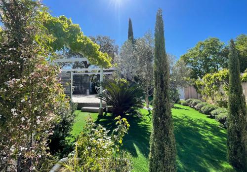 a garden with trees and a building in the background at La Roca Flora in Plan-de-la-Tour