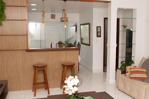 a living room with a bar and two stools at Mar Y Suites in Cabo Frio