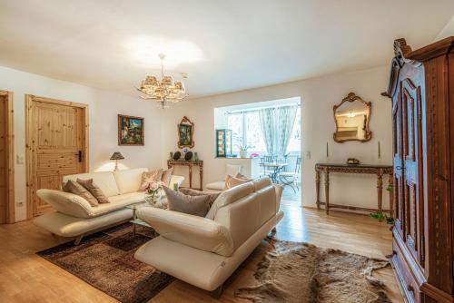 a living room with two couches and a chandelier at Panorama Spa Lodges DAS.SCHILLER in Bad Gastein