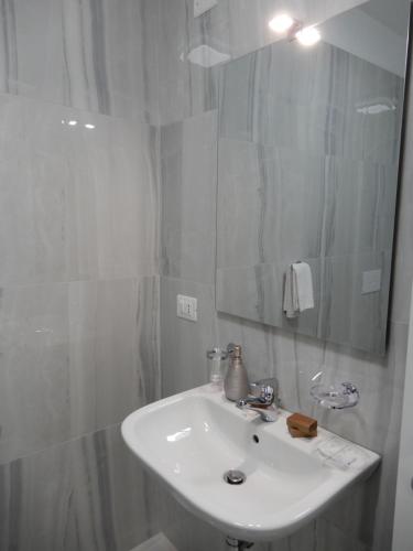 a white bathroom with a sink and a mirror at Middle Town Palace in Tropea