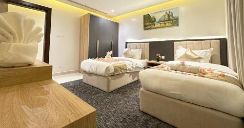 a hotel room with two beds and a mirror at تمايا الخبر Tamaya Alkhobar in Al Khobar