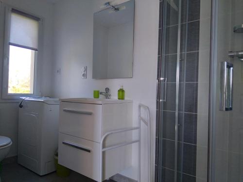 une salle de bain blanche avec un lavabo et une douche dans l'établissement Petite maison à la campagne, à Le PARC