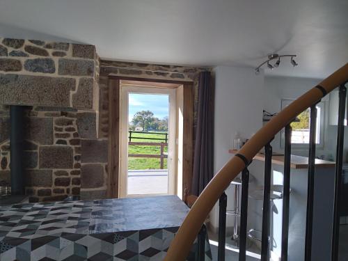 une cuisine avec une cheminée en pierre et une fenêtre dans l'établissement Petite maison à la campagne, à Le PARC